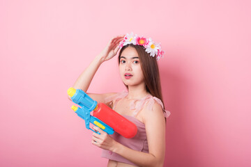 Young happy beauty Asian woman holding plastic water gun at Songkran festival, Thailand. Thai New Year's Day. Isolated on black background.