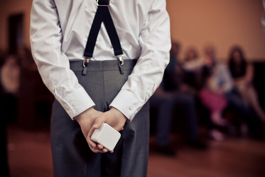 Rear view of pageboy holding wedding ring box in ceremony