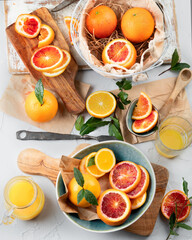 Oranges and juice in basket on light background