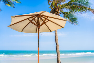 Umbrella and chair around sea beach ocean with coconut palm tree
