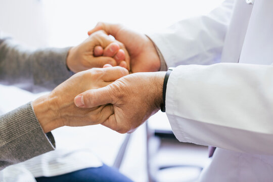 Close-up of doctor holding senior patient hands
