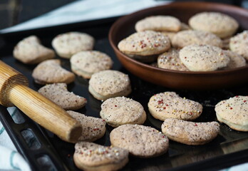 Homemade shortbread cookies sprinkled with sugar in a clay plate on a baking sheet on a dark wooden table.Confectionery background.