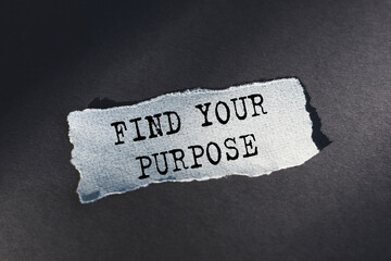 FIND YOUR PURPOSE - text on torn paper on dark desk in sunlight.