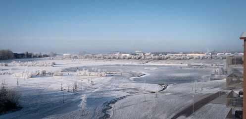 The lake R&aring;bysj&ouml;n is completely frozen and people are ice skating on it on a cold winter morning in Lund Sweden