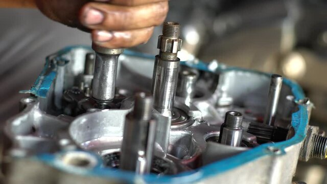  Motorcycle engine during service repair by qualified mechanic hand close up