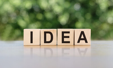 Wooden cubes building word IDEA on blurred background