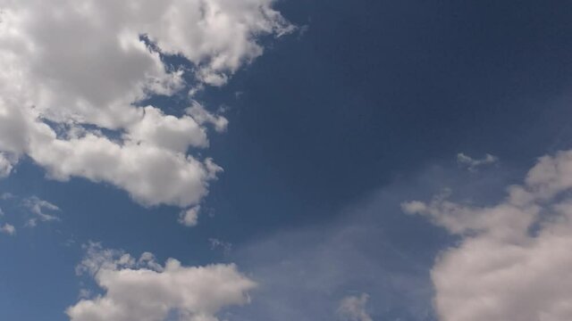 Low angle view TimeLapse of Beautiful sunny blue sky. White cumulus fluffy clouds. b-roll footage. Sun Flare On Blue Sky. 
