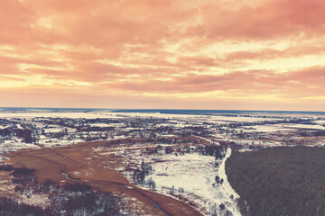 Panoramic top view of winter snowy countryside at sunset