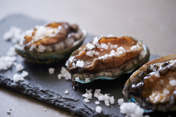 Fresh raw abalone and salt on marble 
