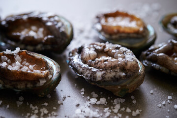 Fresh raw abalone and salt on marble 