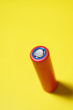 High angle view of red battery on yellow background