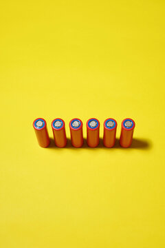 High angle view of batteries on yellow background