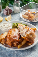 Fish in beer batter and chips with green pea and tartar sauce