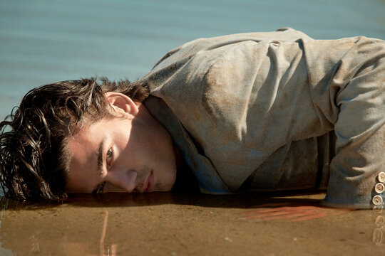 Man lying on shore at beach