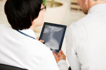 Doctors looking x-ray report in tablet computer