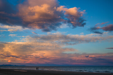 Pareja a contraluz paseando al atardecer en la playa