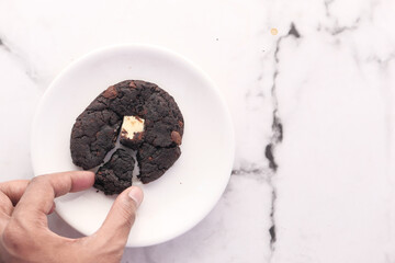 hand pick chocolate cookies on plate 