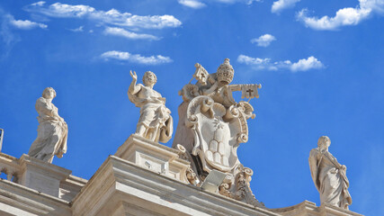 Fototapeta na wymiar Zoom detail photo of sculptures on top of Saint Peter basilica in Vatican City, Rome, Italy