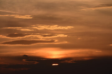 Fototapeta na wymiar Sun low on the horizon turns sky orange