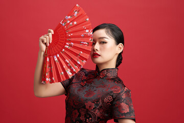 Asian chinese woman in traditional dress on red background. Chinese new year festival.