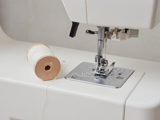 Sewing process, close up seamstress hands sew white clothes with sewing machine.