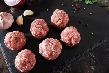 raw minced pork cutlets on a dark background