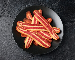 Fried crunchy plant based vegan Bacon pieces in a black plate