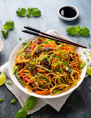 Stir fry noodles with beef and vegetable in white bowl. asian style food