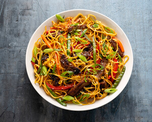 Stir fry noodles with beef and vegetable in white bowl. asian style food