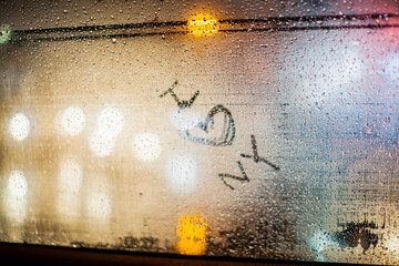 Close-up of text on condensed glass window