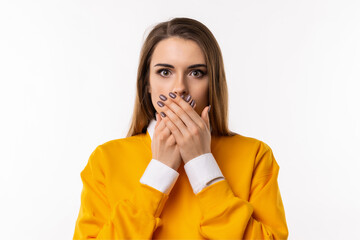 Frustrated brunette girlis covering mouth with two hands not willing to disclose something...