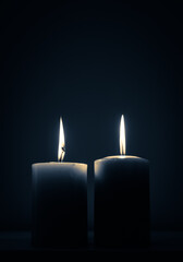 two candles burning in dark
