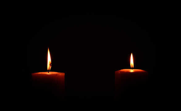 two candles burning in dark