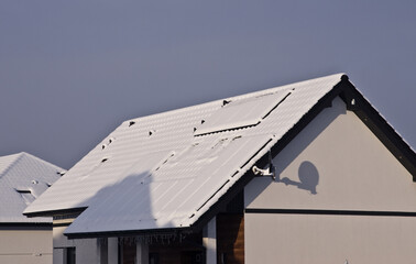 Roof of a house with solar panels completely covered with snow