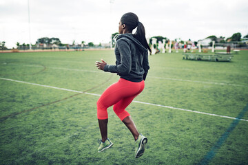 Full length of determined female athlete exercising on field