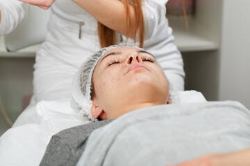 Young beautiful woman receiving facial massage