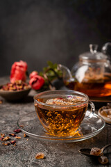 herbal flower tea from the petals of rose in a glass cup on dark gray background