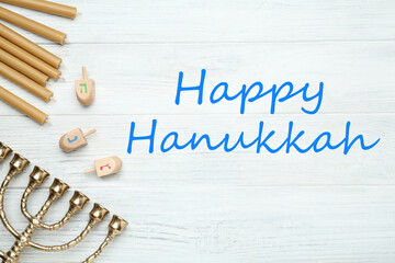 Happy Hanukkah. Traditional menorah, candles and dreidels on white wooden table, flat lay