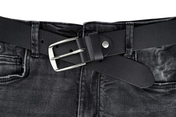 Black leather belt on denim. Jeans belt. Fastened fashionable men's leather belt with dark matted metal buckle isolated on white background. Black belt for men. Male accessory.