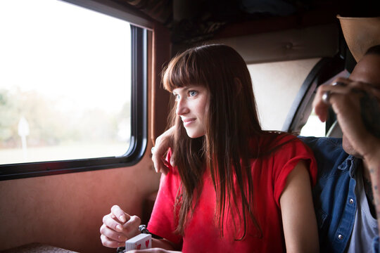 Woman sitting by window with boyfriend in camper van