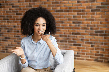Young mixed-race businesswoman or a female entrepreneur with afro hairstyle wearing casual clothes,...