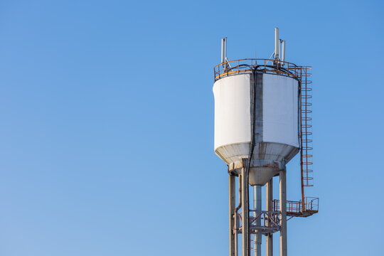 Water supply tower set against blue sky and white snow. Winter landscape.