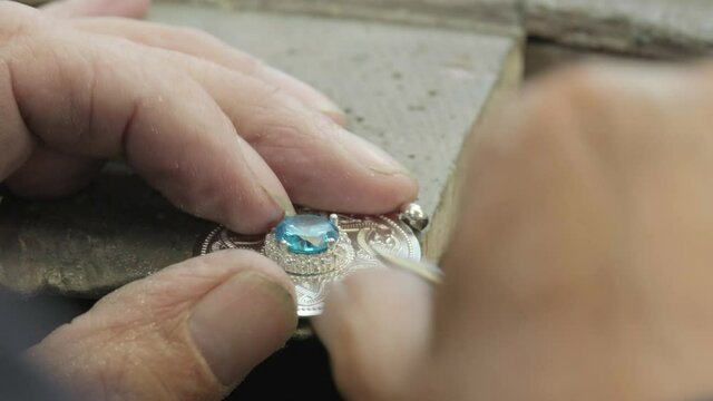Close ups of a craftsman making jewellery in a workshop.