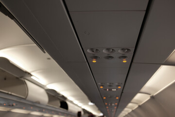 Airplane interior with overhead luggage compartments and console buttons