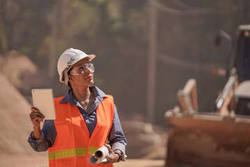 The female engineer is examining the work in the laptop and planning work for the road construction.