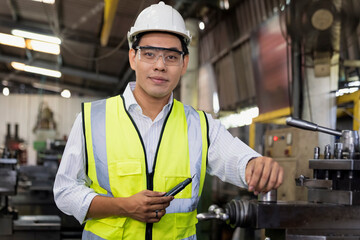 Manufacturing worker. Professional Asian worker controlling the work. Cheerful Factory Worker Posing.