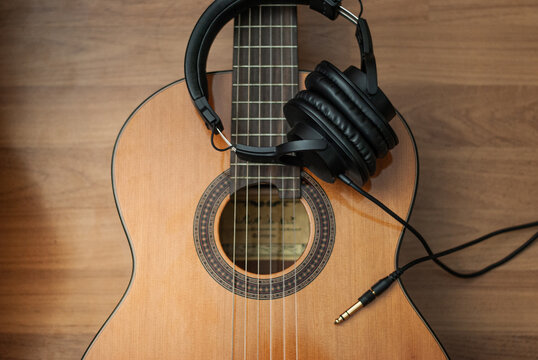 Acoustic guitar resting against a wooden background