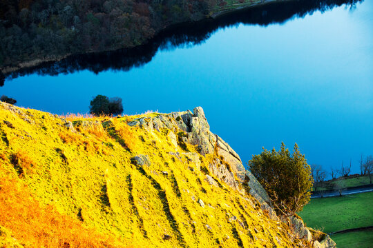 The last rays of evening light catching Nab Scar, looking down on Rydal Water, Lake District, UK.