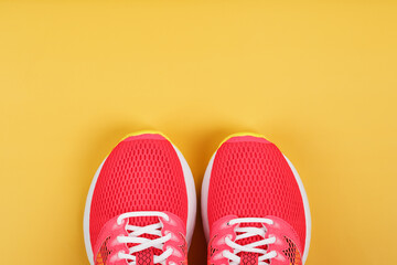 Sports sneakers, pink on a yellow background with free space.