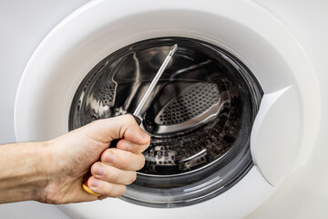 laundry washing machine repair concept. handyman fix washing appliance